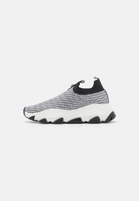 Strick-Sneaker mit schwarz-weißem Muster, im Slip-On-Design, gepolsterter weißer Sohle und einer strukturierten Gummisohle für besseren Halt.