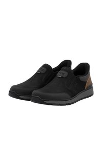 Zapatos negros tipo slip-on hechos de cuero texturizado, con un acento marrón en el talón y una suela de goma flexible de perfil bajo.
