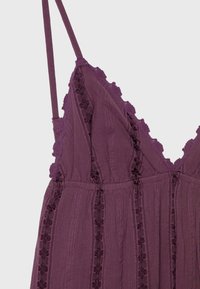 Robe sans manches violette avec fines bretelles, col en V, rayures verticales en dentelle florale et bordure en dentelle à volants le long du bord supérieur.