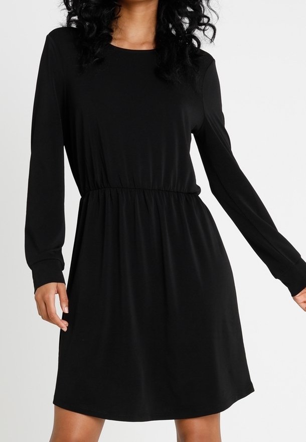 Svart långärmad klänning med rund halsringning, elastisk midja och slätt tyg, som har en lös passform och slutar ovanför knäna.