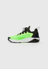 Scarpa sportiva con tomaia sintetica verde neon brillante, dettagli neri, design texture, suola intermedia bianca e suola esterna in gomma nera.