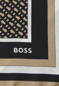 Silk scarf featuring a geometric pattern in black and beige, bordered with white and black stripes. The brand name "BOSS" is displayed prominently.