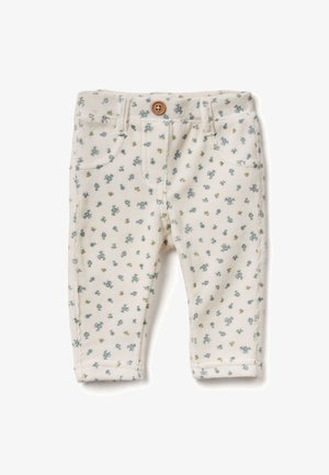 Pantaloni per bambini in cotone color crema con piccole stampe floreali blu e gialle, con un bottone in legno e due tasche frontali. Tessuto in corduroy testurizzato.