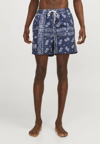 Marineblaue Badeshorts mit weißem Paisleymuster, Kordelzugbund und Seitentaschen; aus leichtem, schnell trocknendem Material gefertigt.