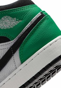 Φτέρνα αθλητικού παπουτσιού Air Jordan με δερμάτινα πάνελ σε πράσινο, μαύρο και λευκό, με ανάγλυφο λογότυπο φτερών Air Jordan και υφή λευκής ενδιάμεσης σόλας.