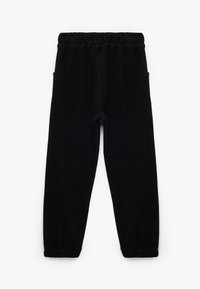 Sorte strikkede bukser med en elastisk talje, to sidelommer og tapered manchetter. Teksturen er vævet og let ribbet.