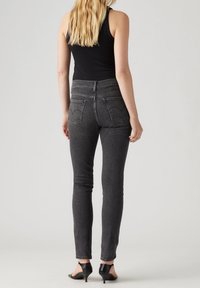 Höga svarta denimjeans med en figurnära passform, med en sömlös bakficka och stickade detaljer längs fållarna.