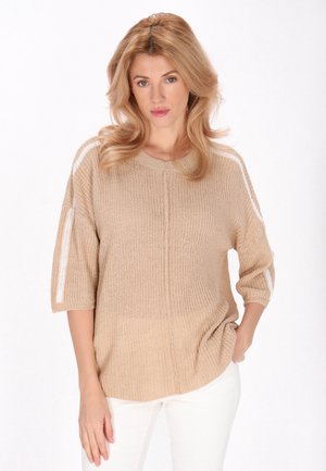 Pull en tricot beige à coupe décontractée, avec un col rond côtelé et des rayures blanches sur les épaules. Manches courtes et tissu texturé.