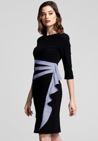 Vestito nero con maniche a tre quarti, caratterizzato da un accento arricciato lavanda drappeggiato in vita, creando una silhouette strutturata.