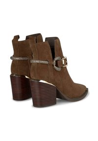 Botas de ante marrón hasta el tobillo con punta abierta, con detalles de hebilla metálica y un tacón de bloque a rayas de madera. Superficie texturizada, altura de tacón de 7,5 cm.