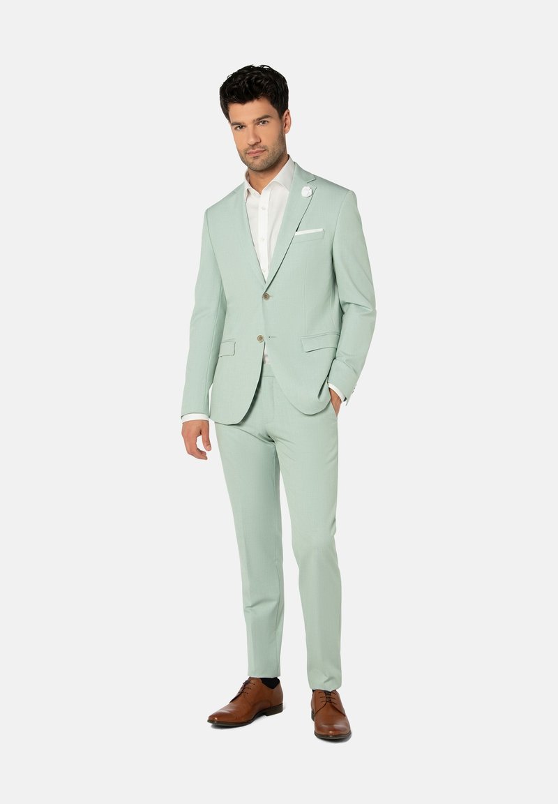 Helles mintgrünes Sakko mit slim fit, Revers, einer Knopfschließe und weißem Hemd. Braune Lederschuhe runden den Look ab.