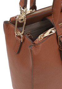 Bruine leren handtas met gouden hardware, voorzien van een ritssluiting en meerdere compartimenten. Gladde textuur met zichtbare stikseldetails.