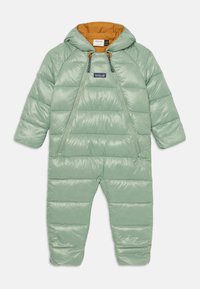 Fato de neve verde com capuz, fecho dianteiro e interior laranja. Apresenta seções acolchoadas e detalhes elásticos no pescoço e punhos.