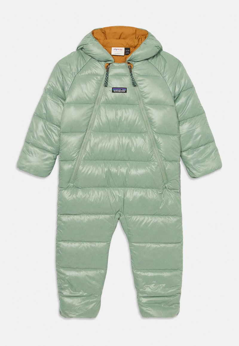 Fato de neve verde com capuz, fecho dianteiro e interior laranja. Apresenta seções acolchoadas e detalhes elásticos no pescoço e punhos.