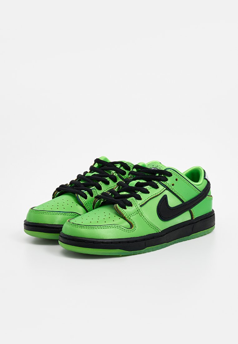 Zapatillas de cuero verdes con acentos negros, caja de puntera perforada, cordones negros y una entresuela negra. Presenta el logo de Nike en los lados.