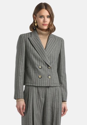 Grijze gestreepte dubbelzijdige blazer met een getailleerde pasvorm, grote knopen en een sjaalkraag, gecombineerd met een beige turtleneck eronder.