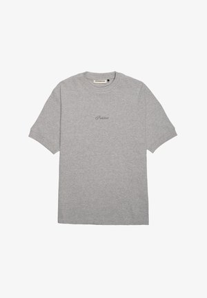 Pilkas medvilninis marškinėliai su apvaliu kaklu, trumpomis rankovėmis ir mažu tamsiai pilku "Draudžiama" logotipu priekyje, centre.