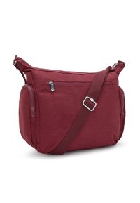 Bordeaux crossbody-väska med justerbar rem, framficka med zipp, och två sidofickor med zip på en vit bakgrund.