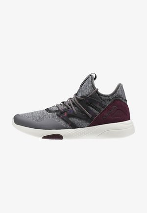 Zapatilla deportiva gris y granate con parte superior de punto, jaula de cordones de plástico negro con patrón, suela blanca texturizada y logotipo de Reebok en el contrafuerte del talón.