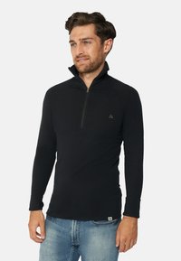 Schwarzer Langarmpullover mit halbem Reißverschluss und Kragen, mit glatter Textur und dezentem Branding auf der Brust.