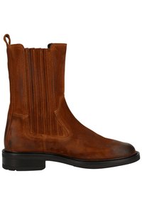 Bottine en daim marron avec des panneaux élastiques sur les côtés et une finition texturée, présentant un bout rond et une semelle en caoutchouc noir basse.