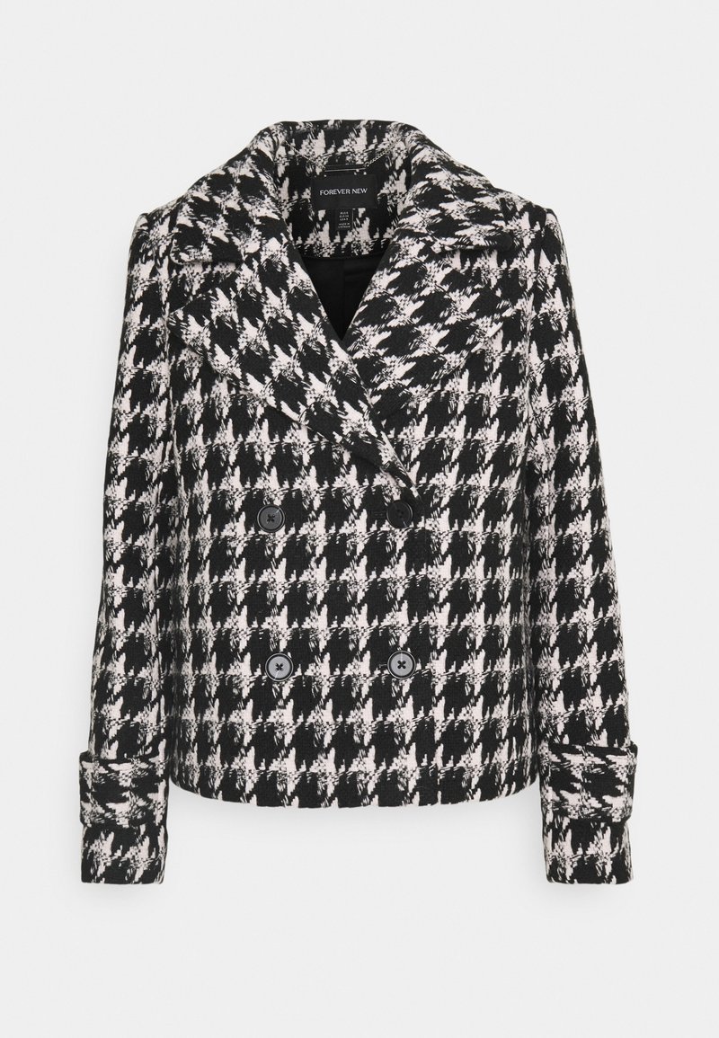 Černobílý kabát s houndstooth vzorem, dvouřadový, s širokým límcem a dvěma předními knoflíky, vyrobený z texturované látky s pevným střihnutím.