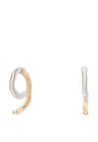 Pendientes de oro y plata con un diseño ondulado. Uno tiene un acabado de plata pulida y el otro presenta un acabado dorado brillante.