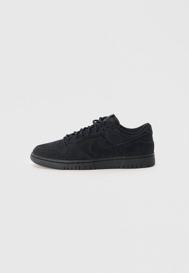 Sneakeruri negre din suede cu vârful perforat, șireturi și un discret swoosh Nike pe lateral, prezentate din profilul drept pe un fundal alb.