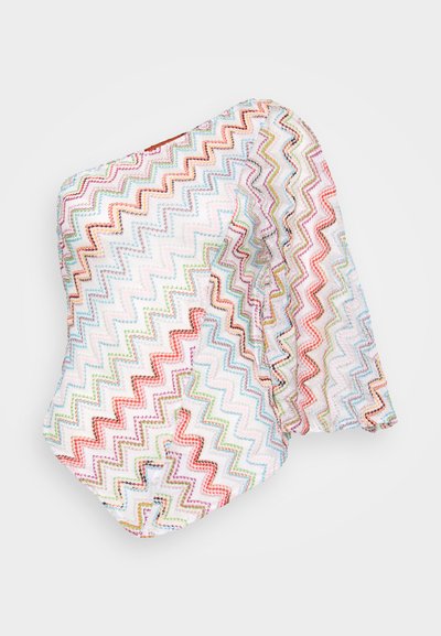 Värikäs siksak-kuvioinen yläosa, jossa on yksi pitkä hiha. Valmistettu kevyestä kankaasta, jossa on kevyt kiilto, pääasiassa valkoisella taustalla.