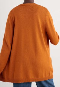 Långärmad orange kofta i strukturerad stickad kvalitet, med ribbat krage och nederkant, samt sidofickor och avslappnad passform.