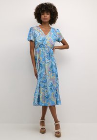 Sininen paisley-kuvioitu mekko, jossa on lyhyet puff-hihat, V-pääntie ja kerroksellinen helma. Kevyestä kankaasta valmistettu, sisältää eloisia keltaisia ja vaaleanpunaisia yksityiskohtia.