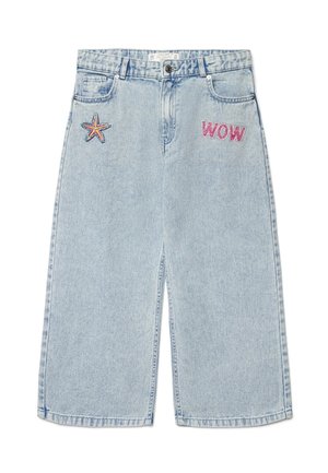 Pantaloncini di denim azzurro chiaro con una toppa a forma di stella marina sulla tasca sinistra e una toppa rosa con la scritta "WOW" sulla parte superiore della coscia destra.