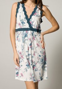 Robe fleurie blanche avec des fleurs bleues et roses ; finition en dentelle le long de l'encolure ; sans manches ; jupe froncée. Tissu doux et léger.
