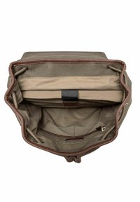 Wnętrze plecaka z płótna z beżową podszewką, wyściełana kieszeń na laptopa zabezpieczona czarnym paskiem oraz kieszeń zapinana na zamek wewnątrz.