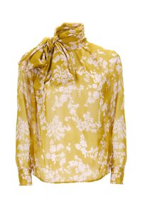 Blusa floreale gialla realizzata in tessuto trasparente, con un fiocco al collo e maniche lunghe, decorata con motivi bianchi a fioritura su tutta la superficie.