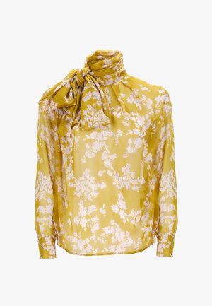 Blusa floreale gialla realizzata in tessuto trasparente, con un fiocco al collo e maniche lunghe, decorata con motivi bianchi a fioritura su tutta la superficie.