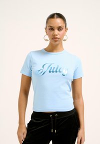Világoskék, rövid ujjú, környakú, puha pamutból készült crop t-shirt, amelyen csillogó fémes "Juicy" felirat látható, szép írásos betűtípussal.