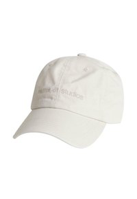 Cappellino da baseball crema in cotone con visiera curva e logo ricamato "returnkit studios" sulla parte anteriore. Finitura in tessuto texturizzato.