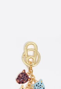 Cierre de metal dorado con tres encantos de peces coloridos en color marrón, azul y crema. Cada encanto presenta manchas y formas distintas.