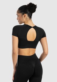 Schwarzes, kurzärmeliges Crop-Top mit einem Schlüssel-Ausschnitt auf der Rückseite. Hergestellt aus elastischem Stoff, zeichnet es sich durch einen figurbetonten Stil und eine glatte Textur aus.