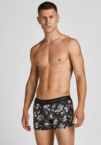 Schwarze Boxer-Shorts mit einem floralen Muster in den Farbtönen Rosa, Blau und Grün. Der elastische Bund zeigt das Logo "JACK & JONES".