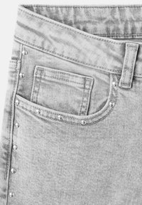 Jeans in denim grigio chiaro con dettagli in metallo argentato lungo le cuciture e una tasca frontale. Tessuto liscio con un design a vestibilità classica.