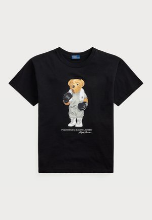 Musta T-paita, jossa on polo-karhun graafinen kuva urheiluasuissa ja nyrkkeilyhanskoissa. Alapuolella teksti "POLO BEAR by RALPH LAUREN."