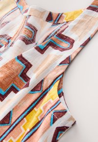 Tissu à motifs présentant des dessins géométriques aux tons chauds d'orange, de marron et de jaune, avec des accents bleus et une finition douce et texturée.