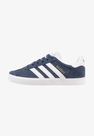 Baskets Adidas Gazelle en suède bleu marine avec des bandes blanches, semelle blanche, lacets et languette au talon, vue latérale sur fond blanc.