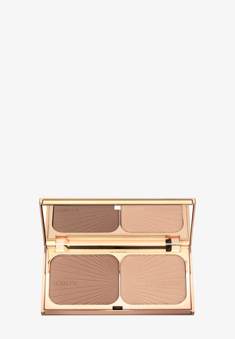 Compact makeup palette with two sections: a dark brown sculpting powder and a light beige highlighter, both with embossed sunburst patterns. Gold casing.