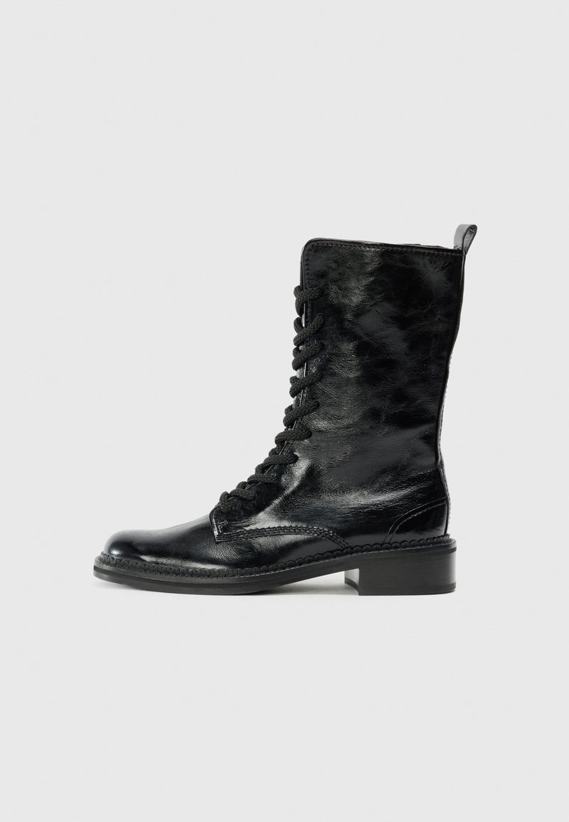 Bottes noires en cuir à cheville avec une finition brillante, dotées d'un laçage à l'avant, d'un bout arrondi et d'un petit talon bloc. Détails de couture visibles.