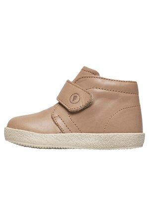 Bottine en cuir tan avec une semelle en caoutchouc texturé, dotée d'une large sangle Velcro et de coutures minimales, conçue pour un enfilage facile.