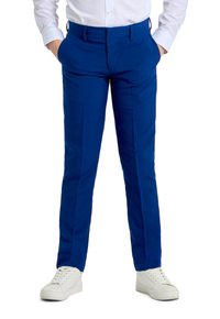 Pantaloni blu sartoriali con tasche frontali, finitura in tessuto liscia e dettagli delle pieghe. Abbinati a sneakers bianche per un look casual.