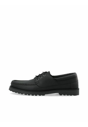 Chaussure mocassin noire en cuir à lacets avec semelle épaisse rainurée et col matelassé, vue de profil sur fond blanc.
